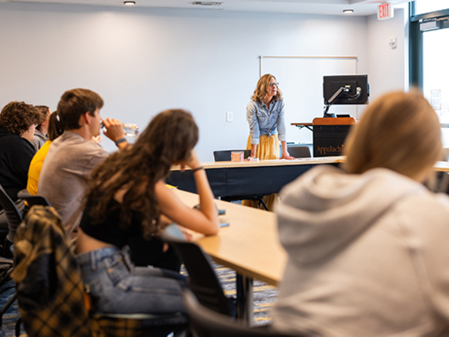 Students engaged in active learning during a Dr. Fredette class, collaborating and participating in discussion.